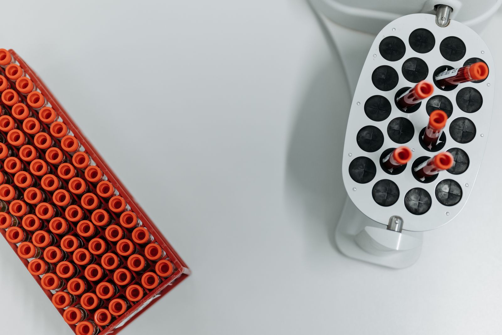 Blood sample tubes in a rack beside a laboratory centrifuge