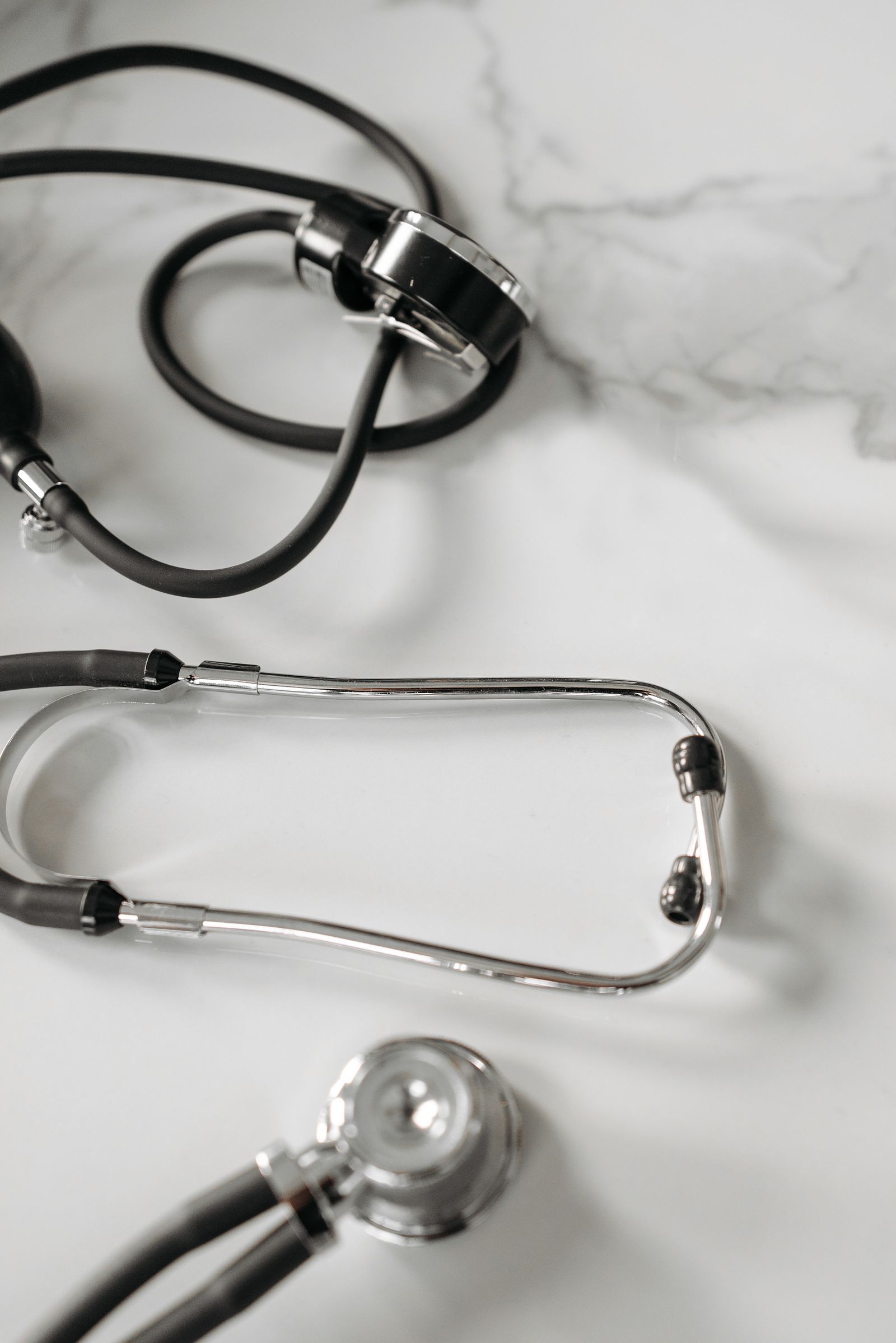 A stethoscope resting on a white marble surface